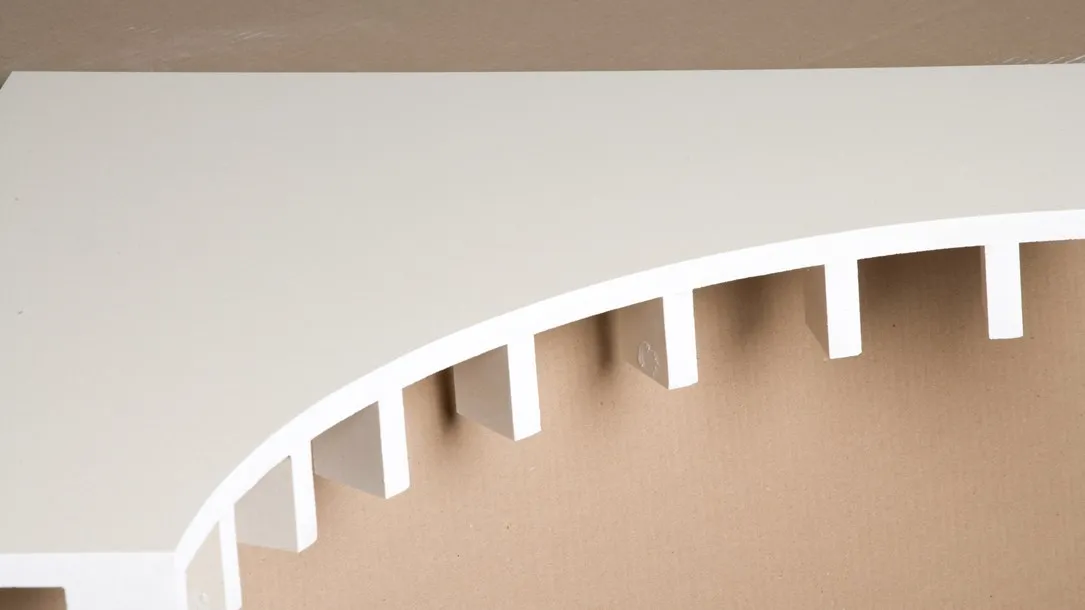Curved Caesarstone quartz surface with precision-cut slots prepared for thermoforming.