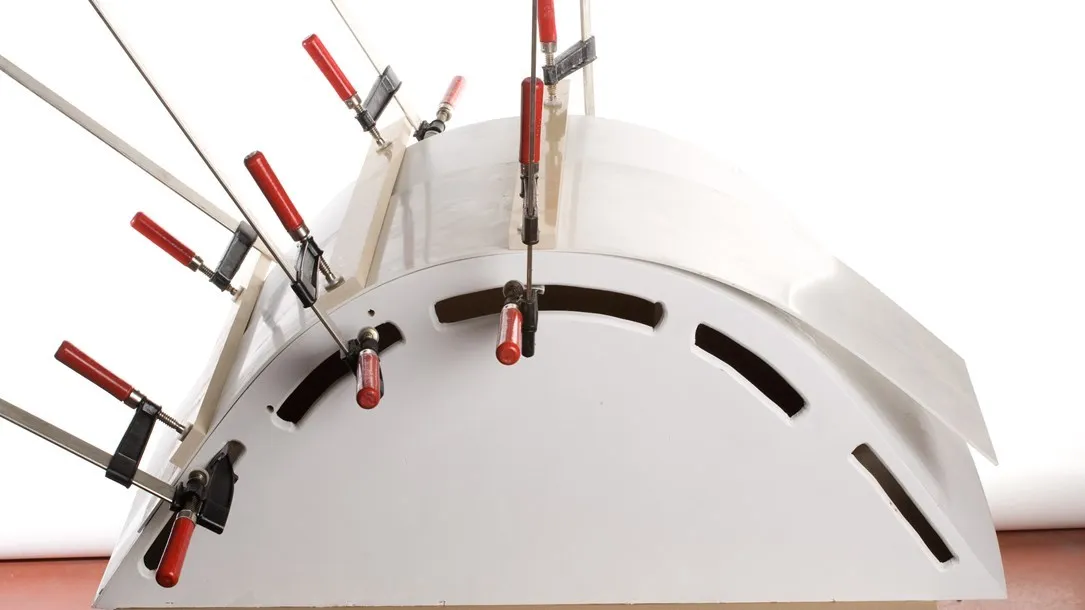 Curved Caesarstone quartz slab secured with clamps during the thermoforming process.